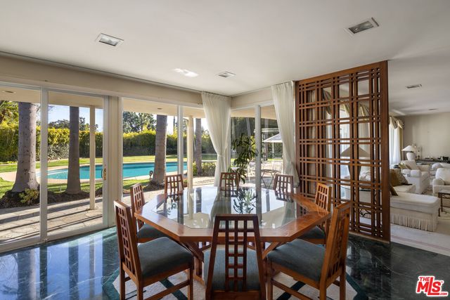 a view of a dining room with furniture large windows and wooden floor