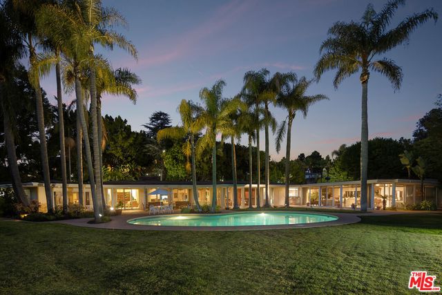 a view of a swimming pool with a garden and trees