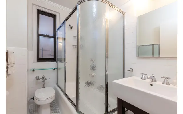 a bathroom with a toilet a sink and mirror