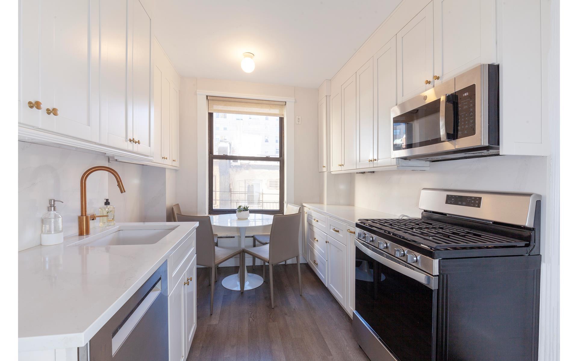 179 East 79th Street, Unit 4CD Manhattan, NY 10075 - Photo 5 of 14 a kitchen with stainless steel appliances granite countertop a stove a sink and a microwave