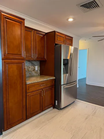 a kitchen with stainless steel appliances granite countertop a refrigerator and a sink