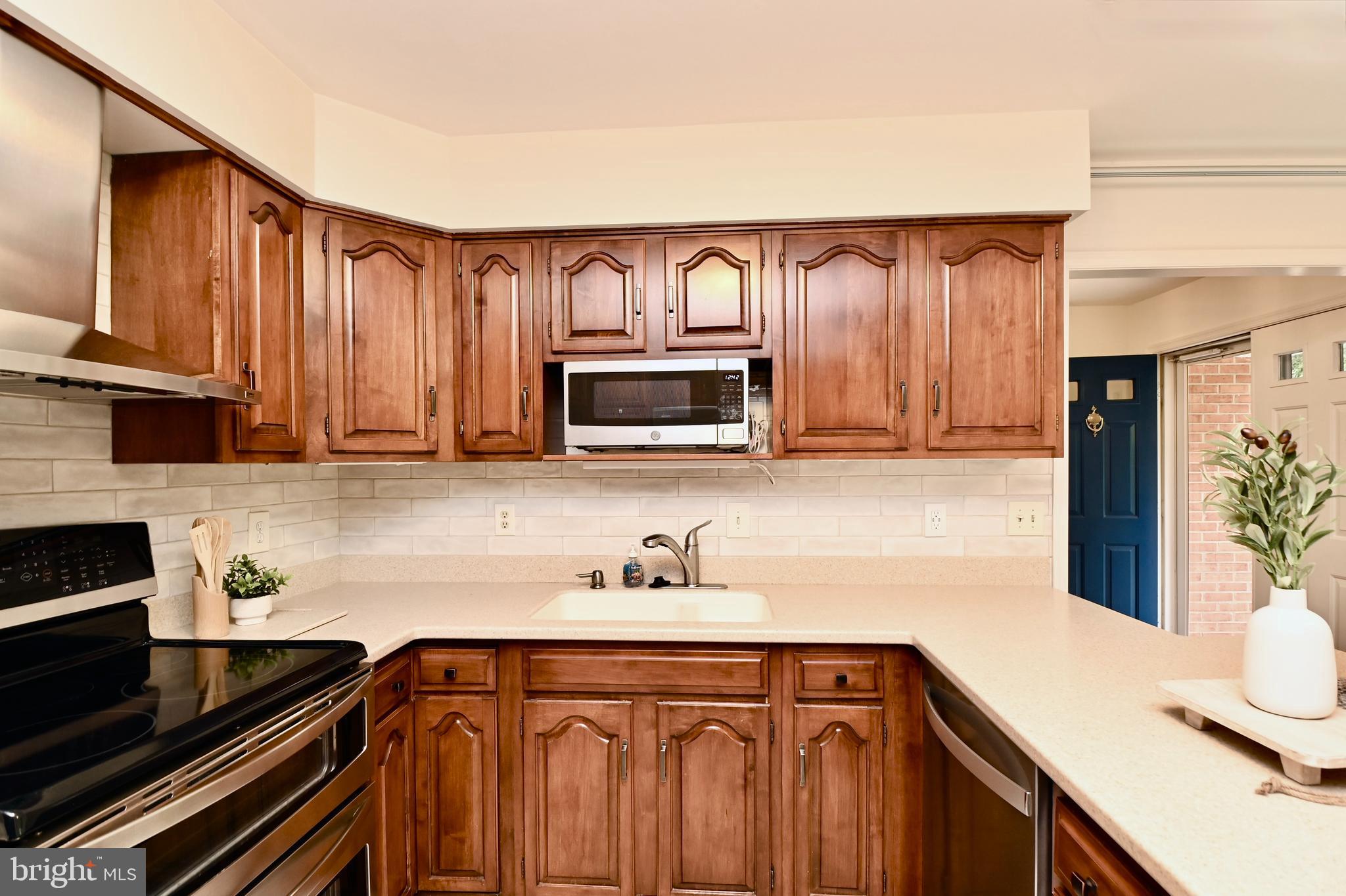 7443 Crestberry Lane Bethesda, MD 20817 - Photo 15 of 46 a kitchen with wooden cabinets and a stove top oven