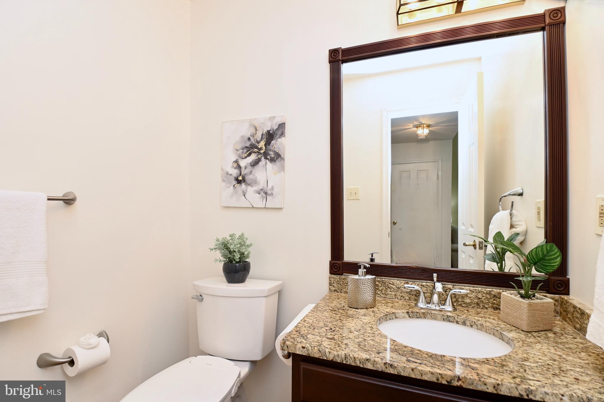 7443 Crestberry Lane Bethesda, MD 20817 - Photo 17 of 46 a bathroom with a granite countertop sink a toilet and a mirror