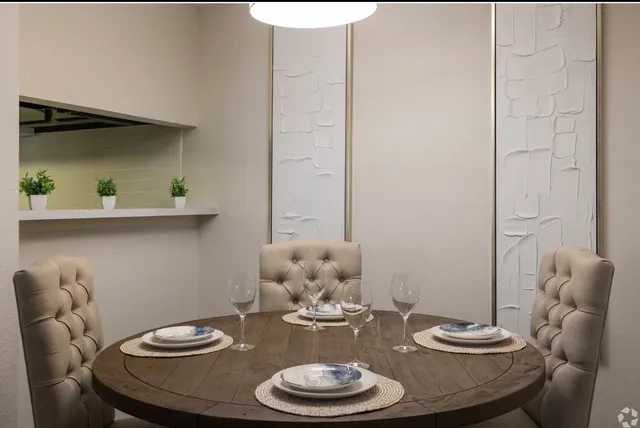 a dining room with furniture and a potted plant