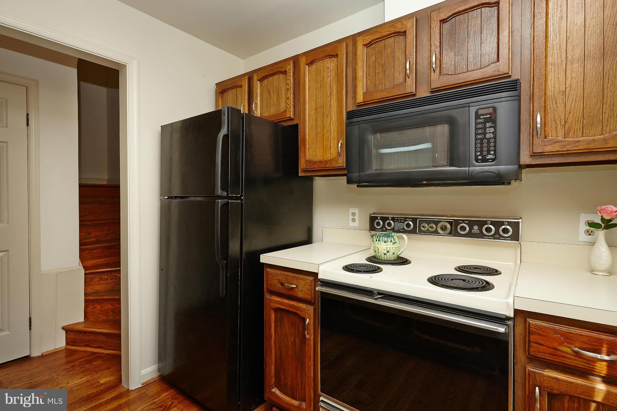 1235 Portner Road Alexandria, VA 22314 - Photo 9 of 25 a kitchen with stainless steel appliances granite countertop a refrigerator stove and microwave with wooden floor