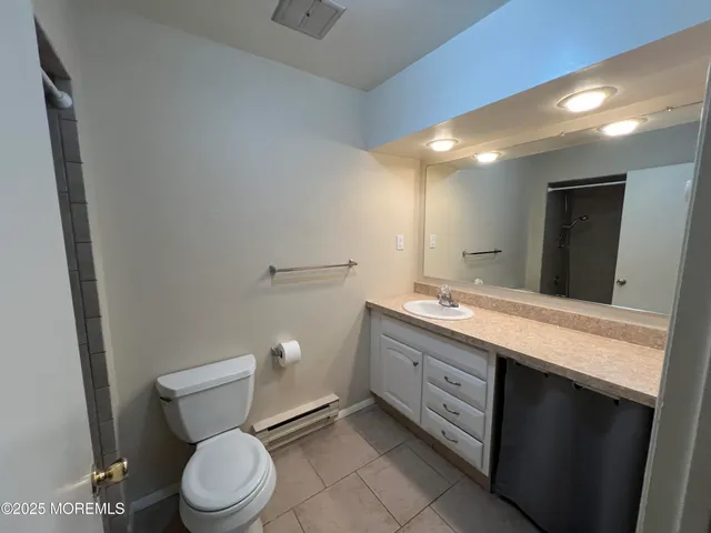 a bathroom with a granite countertop toilet sink and mirror