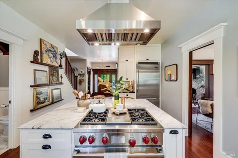 a kitchen with stainless steel appliances granite countertop a stove and white cabinets