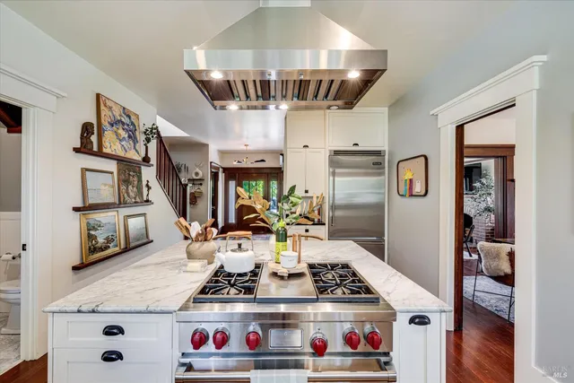 a kitchen with stainless steel appliances granite countertop a stove and white cabinets