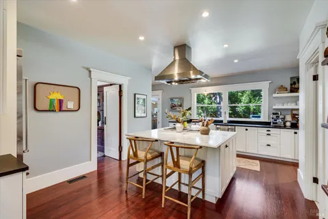a view of a kitchen and dining room with wooden floor a fireplace