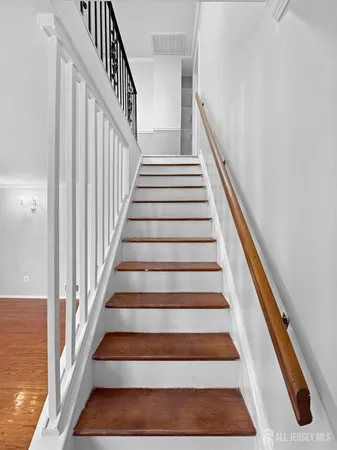 a view of staircase with wooden floor and white walls