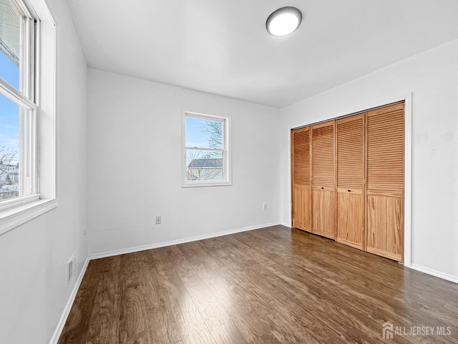 117 Old Post Road Edison, NJ 08817 - Photo 16 of 22 an empty room with wooden floor and windows