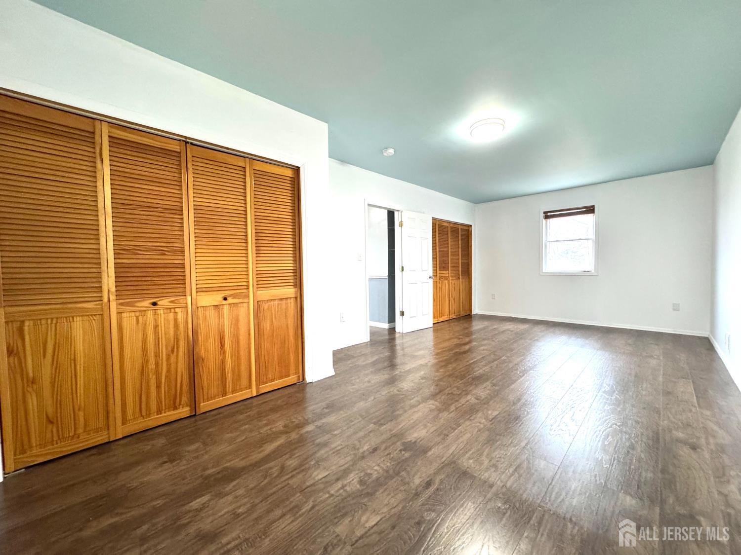 117 Old Post Road Edison, NJ 08817 - Photo 17 of 22 an empty room with wooden floor and windows