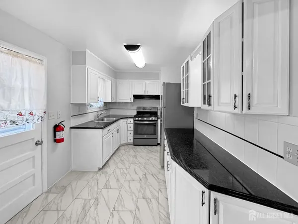 a kitchen with granite countertop white cabinets and white appliances