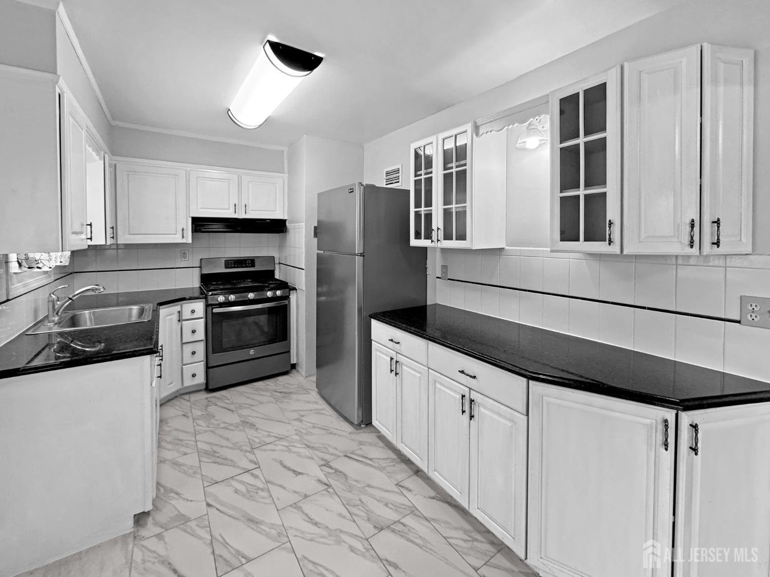 117 Old Post Road Edison, NJ 08817 - Photo 6 of 22 a kitchen with kitchen island granite countertop a stove sink and cabinets