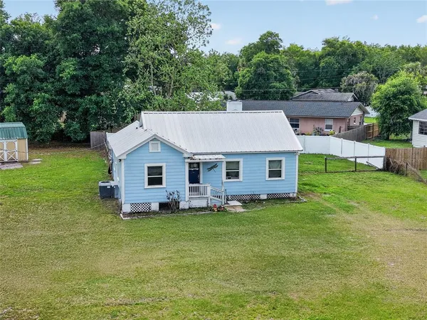 a aerial view of a house in the middle of a big yard
