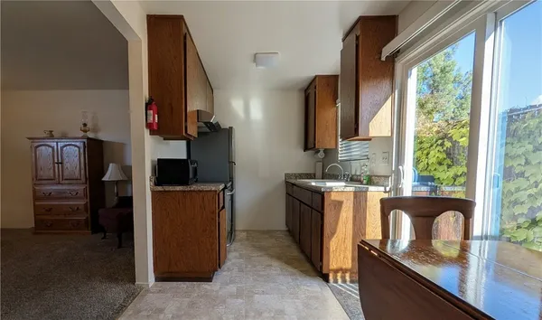 a kitchen with stainless steel appliances granite countertop a refrigerator a stove a sink and dishwasher