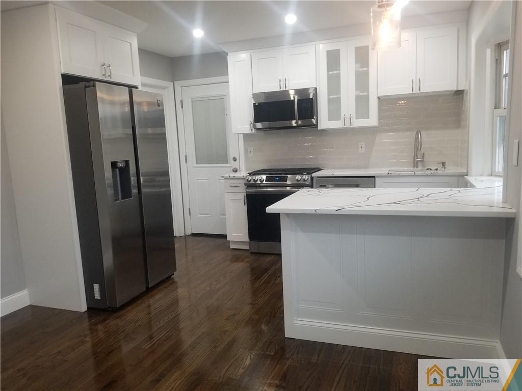 9 Yale Road Old Bridge, NJ 08859 - Photo 5 of 20 a kitchen with stainless steel appliances granite countertop a refrigerator a sink a stove a microwave and wooden floor