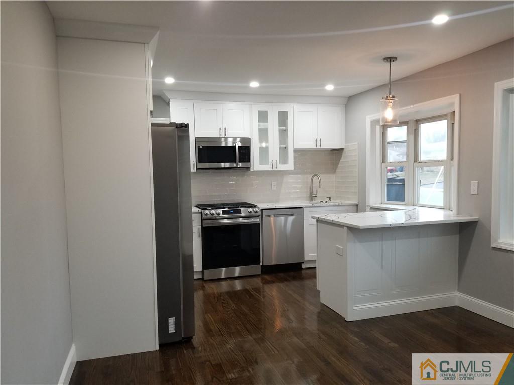 9 Yale Road Old Bridge, NJ 08859 - Photo 8 of 20 a kitchen with stainless steel appliances granite countertop a refrigerator a sink dishwasher a stove and white countertops with wooden floor