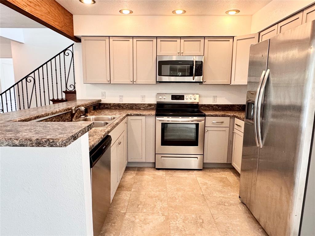 921 Bradleys Bend Tool, TX 75143 - Photo 5 of 29 a kitchen with stainless steel appliances granite countertop a stove a microwave and a refrigerator