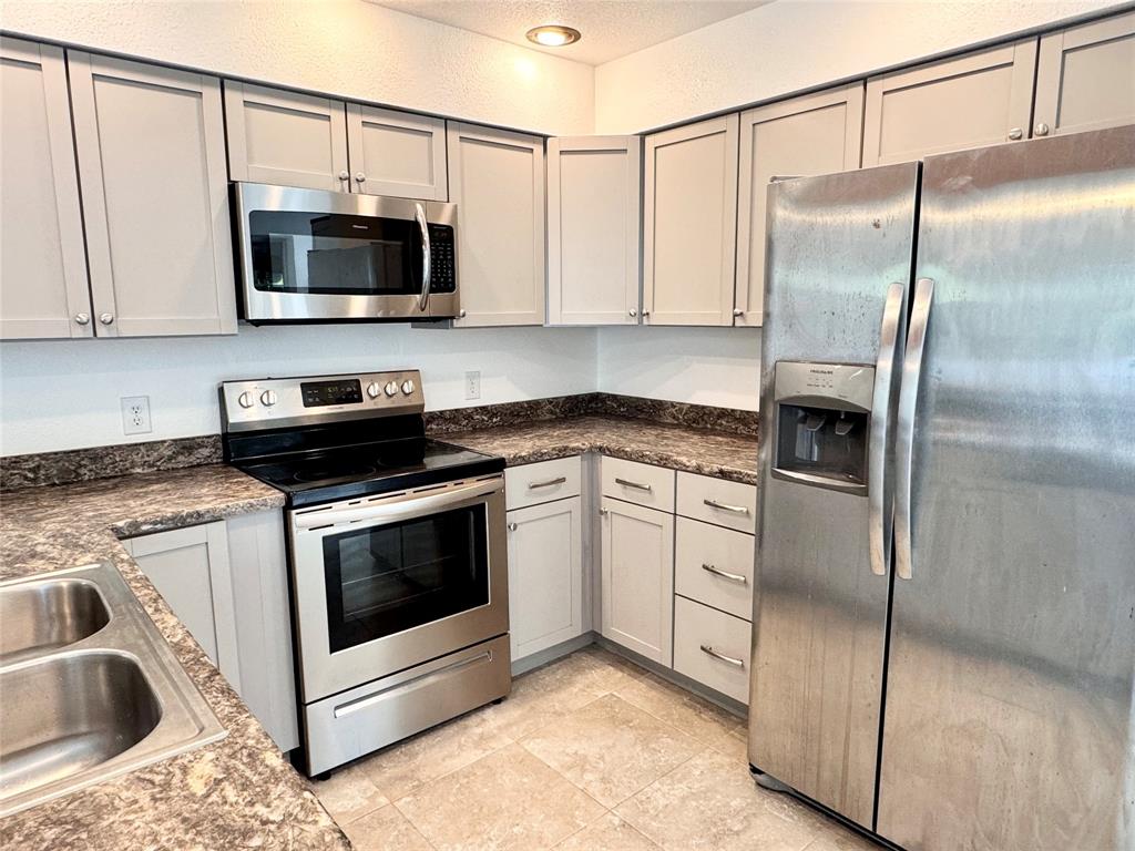 921 Bradleys Bend Tool, TX 75143 - Photo 7 of 29 a kitchen with stainless steel appliances granite countertop a stove a microwave and a refrigerator