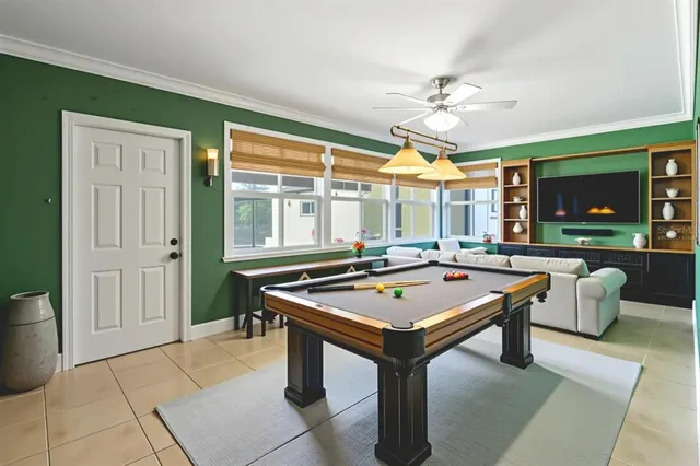a room with pool table and windows