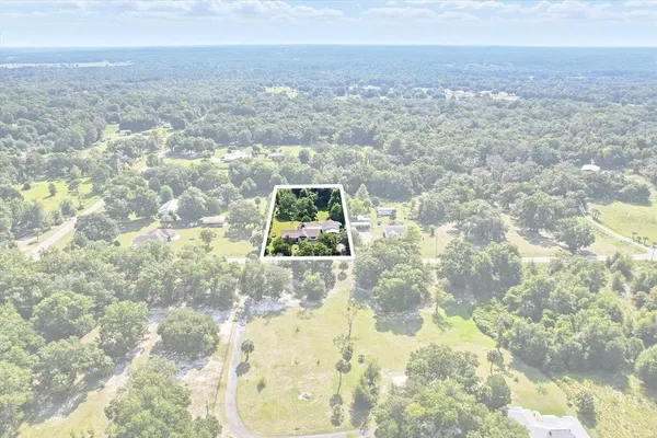 an aerial view of a house with swimming pool and garden