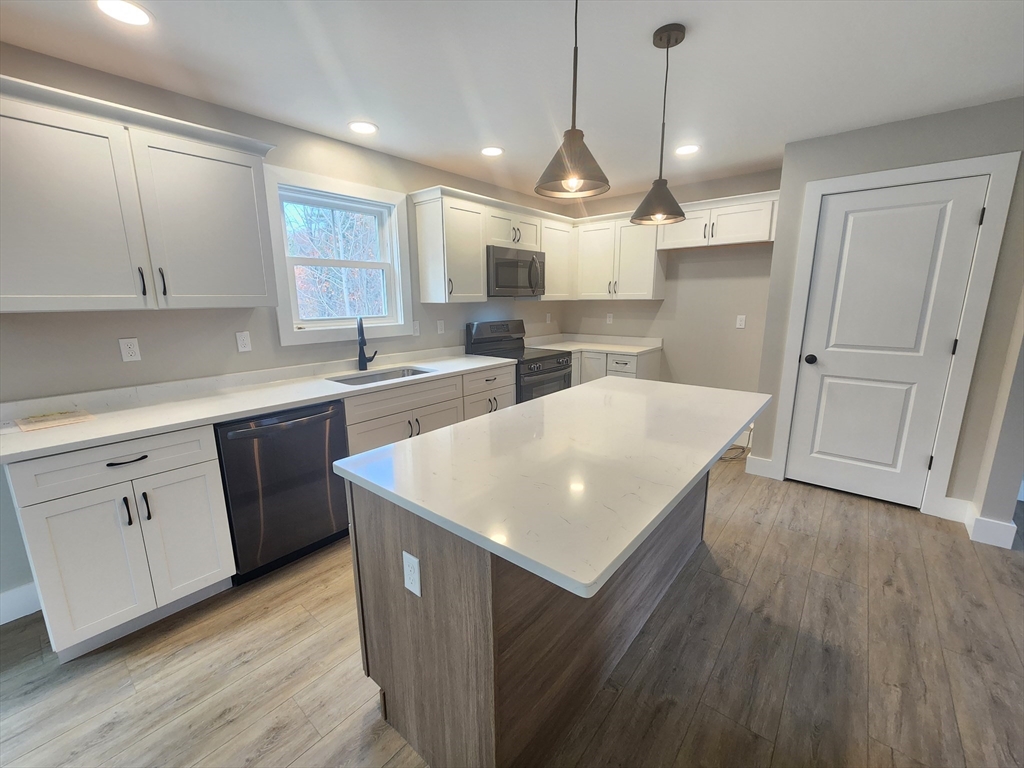 21 Cottage Street Winchendon, MA 01475 - Photo 3 of 12 a kitchen with wooden floors and white cabinets