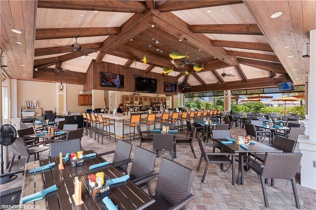 9377 Pocida Court, Unit 202 Naples, FL 34119 - Photo 13 of 30 a room with lots of tables a large window and chairs