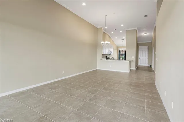 a view of an empty room and a kitchen view