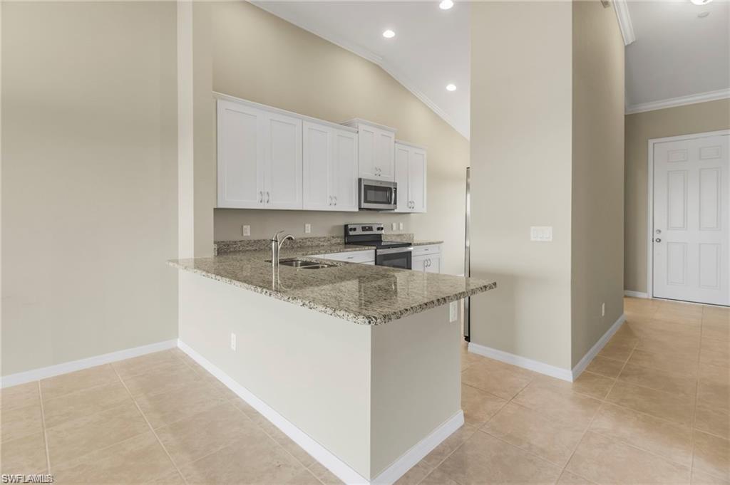 9377 Pocida Court, Unit 202 Naples, FL 34119 - Photo 6 of 30 a kitchen with stainless steel appliances granite countertop a sink stove and cabinets