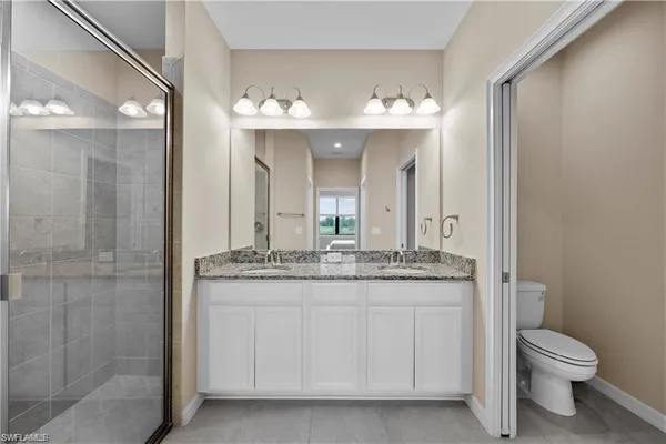a bathroom with a granite countertop sink a toilet and a mirror