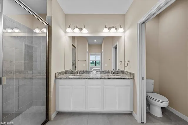 a bathroom with a granite countertop sink a toilet and a mirror