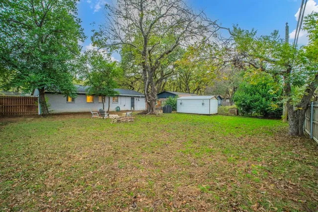 a front view of a house with a yard and a tree