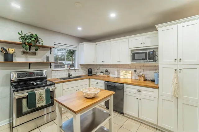 a kitchen with white cabinets stainless steel appliances and sink