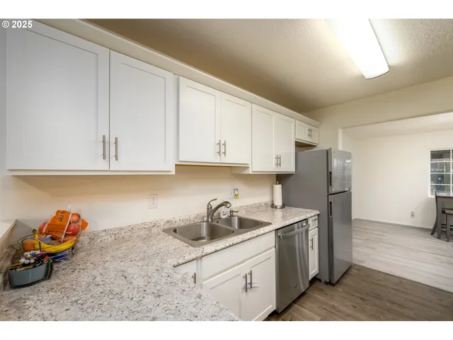 a kitchen with stainless steel appliances granite countertop a sink cabinets and a refrigerator