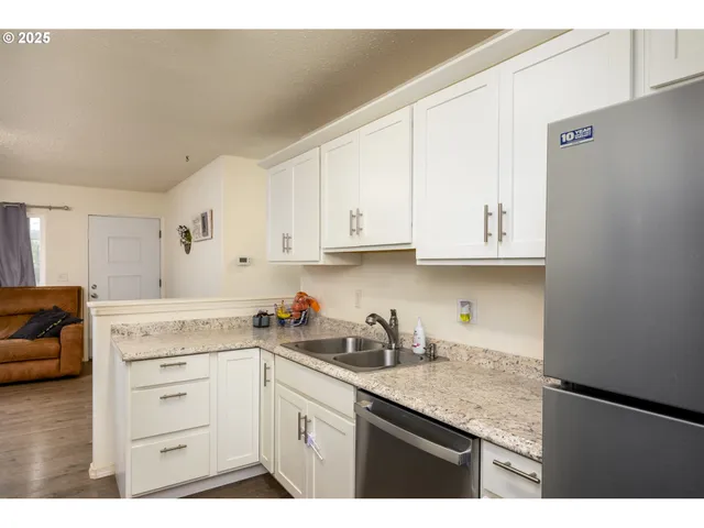 a kitchen with white cabinets and sink
