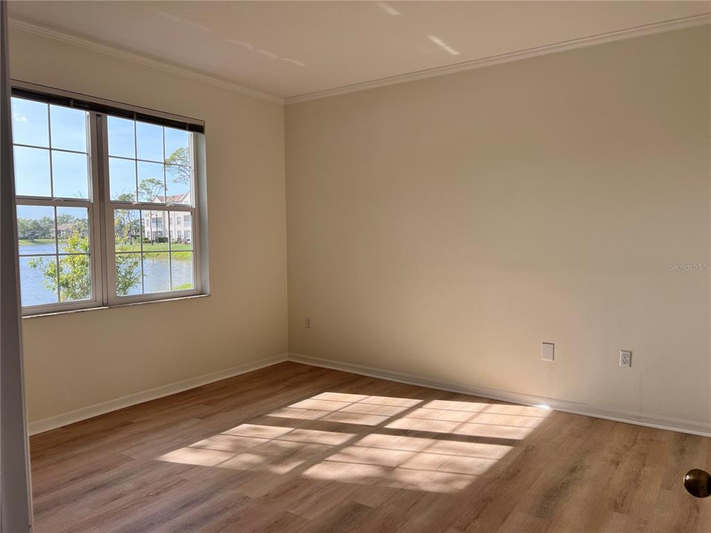 8370 Wingate Drive, Unit 718 Sarasota, FL 34238 - Photo 12 of 49 a view of empty room with wooden floor and fan