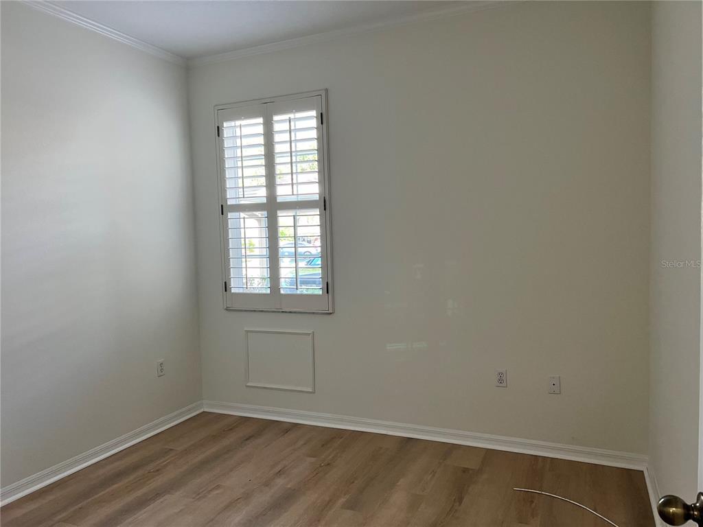 8370 Wingate Drive, Unit 718 Sarasota, FL 34238 - Photo 17 of 49 an empty room with wooden floor and windows