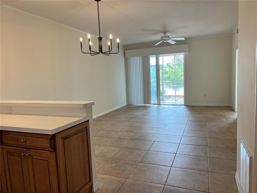 8370 Wingate Drive, Unit 718 Sarasota, FL 34238 - Photo 2 of 49 a view of a room with a chandelier a ceiling fan and windows