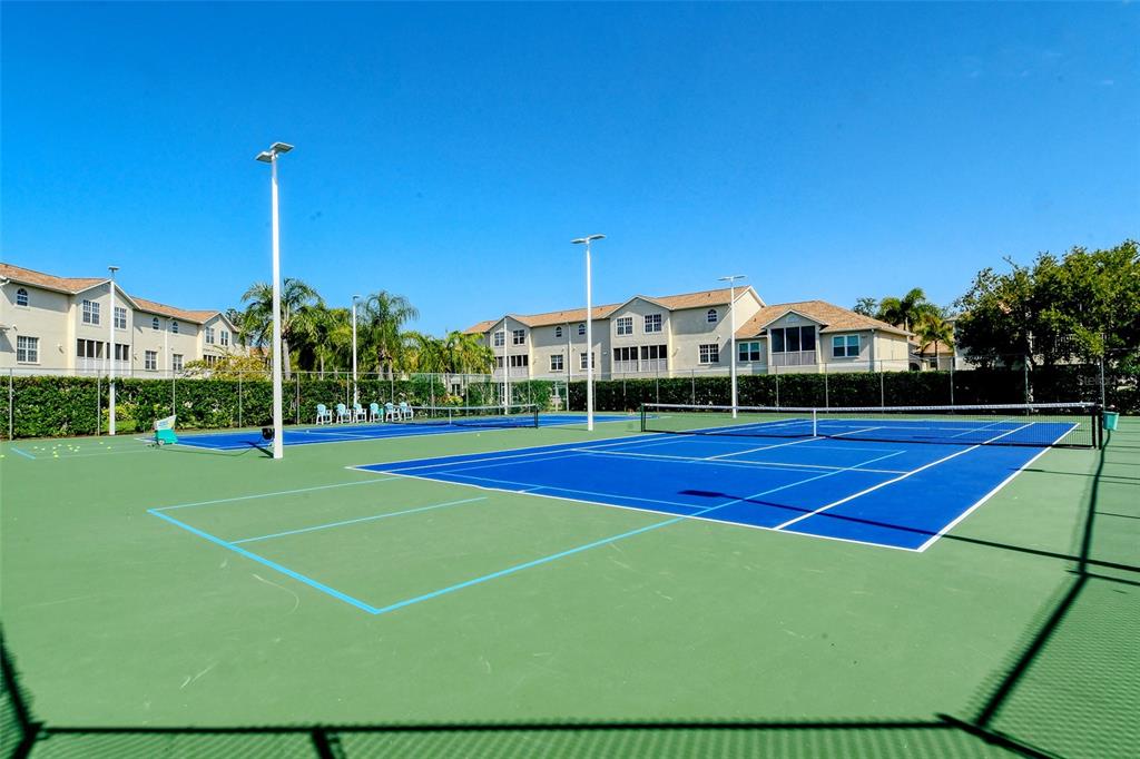 8370 Wingate Drive, Unit 718 Sarasota, FL 34238 - Photo 39 of 49 a view of a tennis ground with large trees