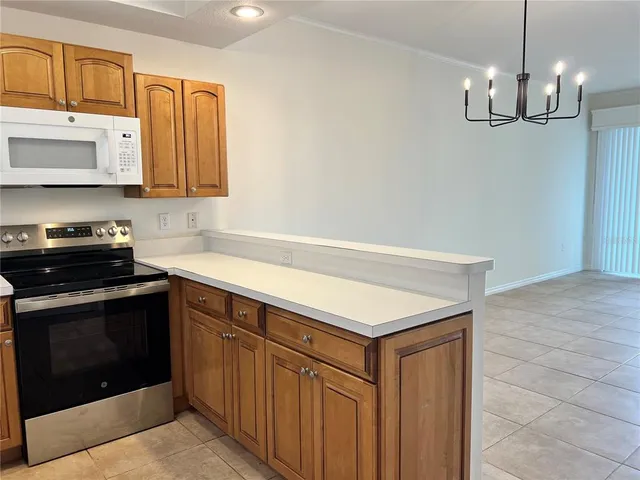 a kitchen with stainless steel appliances granite countertop a sink dishwasher a stove and a microwave oven with cabinets