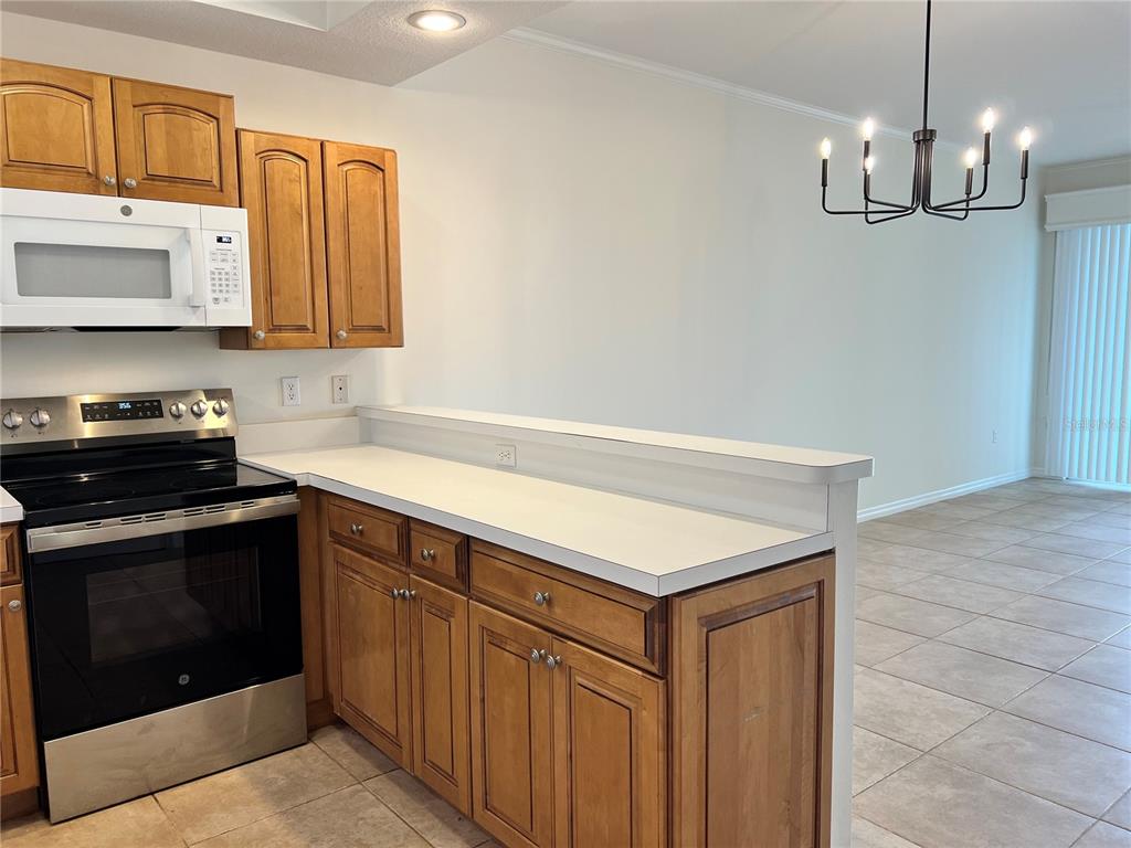 8370 Wingate Drive, Unit 718 Sarasota, FL 34238 - Photo 4 of 49 a kitchen with stainless steel appliances granite countertop a sink dishwasher a stove and a microwave oven with cabinets