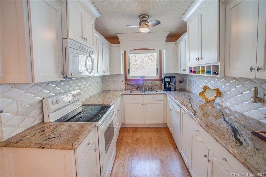 43 Flanders Road East Hampton, CT 06424 - Photo 1 of 1 Custom kitchen beautifully appointed with Italian tile and high end Juperonica Exotica granite. THIS PICTURE IS DECEIVING. IT IS NOT A GALLEY IT IS MUCH WIDER THAN APPEARS.