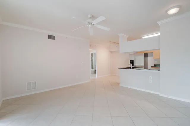 a view of kitchen with kitchen island white cabinets and stainless steel appliances