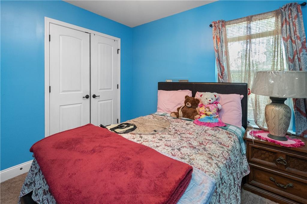 12148 Flannery Lane Hampton, GA 30228 - Photo 7 of 8 a bed sitting in a bedroom next to a window