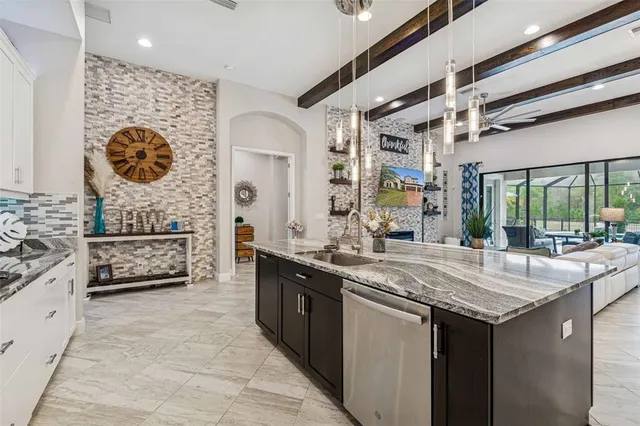 a view of a patio with couches chairs dining table and chairs barbeque grill with a small yard and large trees