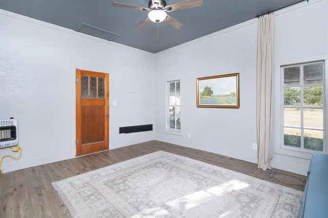 a view of a bedroom with wooden floor and a ceiling fan