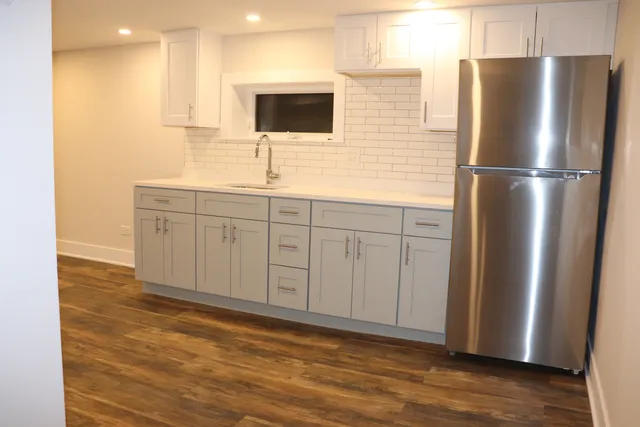 a kitchen with stainless steel appliances granite countertop a refrigerator a sink and a stove