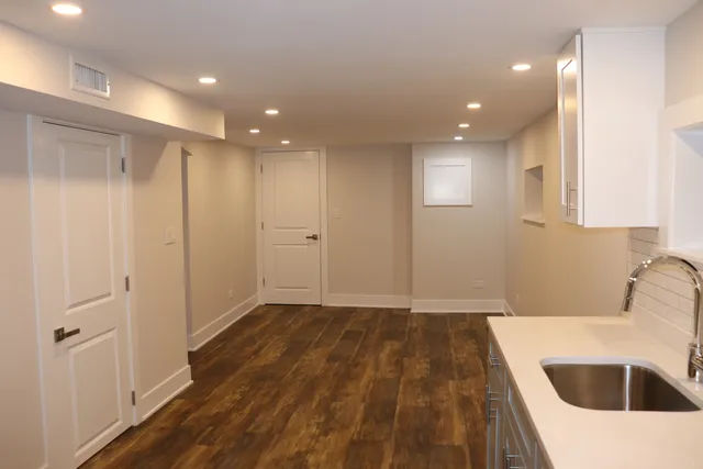 a view of a kitchen with a sink and dishwasher with wooden floor