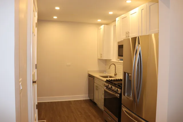 a kitchen with stainless steel appliances a refrigerator and a stove top oven